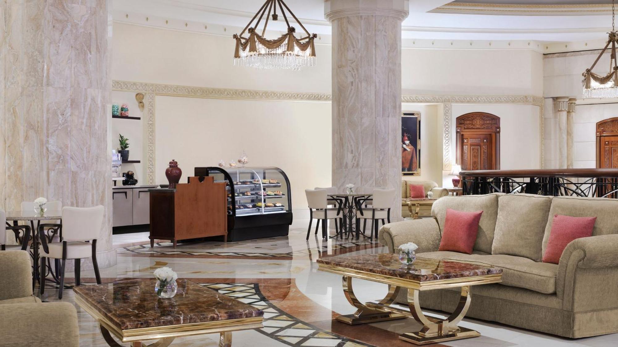 Intercontinental Dar Al Iman Madinah By Ihg Medina Exterior foto The photo shows a luxurious hotel lobby or lounge area. It features elegant marble floors and tall columns. There are comfortable seating arrangements with a sofa and stylish tables that have marble tops. A display case for pastries or refreshments i